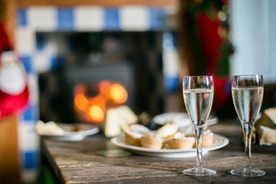 Champagne glasses in front of log burner in a Tresco cottage